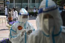 ロックダウン中の中国・上海で、新型コロナウイルスの検査を受けるため列をつくる住民(時事通信フォト)