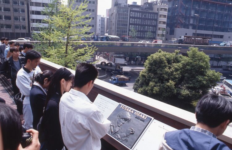 青山学院高等部に通っていた尾崎は、渋谷クロスタワー前の歩道橋で夕日を眺めていたという。三回忌となる1994年4月25日に歌碑が建立された