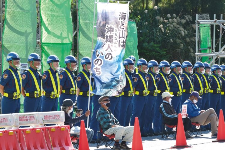 キャンプ・シュワブの新基地建設現場では、建設反対派の抗議にも警備員が一糸乱れぬ隊列で警護する。警備は県外企業が請け負っている