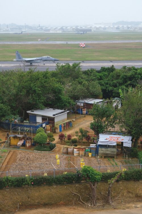 嘉手納飛行場内「黙認耕作地」：フェンスを隔てた嘉手納飛行場の片隅には、日本の地権者による耕作が黙認されている耕作地がある。米軍と住民との間の妥協案のひとつといわれ、沖縄の米軍基地の各所に見られる