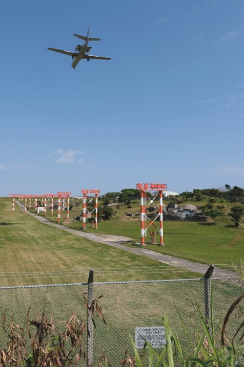 普天間飛行場の敷地内にある誘導灯の右手奥に、沖縄の伝統的な墓である石造りの亀甲墓が見える。日本人が勝手に墓参することは許されず、立ち入るためには米軍の許可が必要