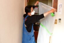 部屋の入り口に感染対策のビニールを張る女将・豊田弘子さん