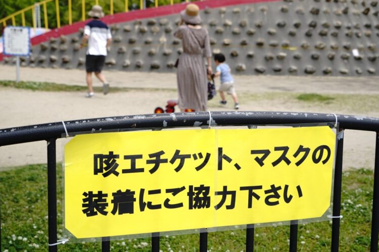 2020年春、公園内に設置された咳チケットとマスク着用を促す看板。マスク着用は義務ではなくお願い（時事通信フォト）