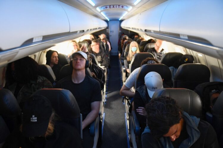 米ロサンゼルス発デンバー行きの旅客機にマスクを着用せずに搭乗する乗客ら。アメリカでは4月末から公共交通機関でのマスク着用義務が解除された（AFP＝時事）