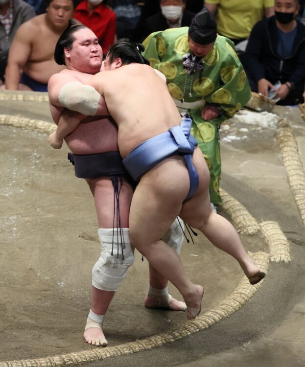 5月場所9日目、翔猿を豪快にきめ出す照ノ富士。両ヒザのサポーターが痛々しい（時事通信社）