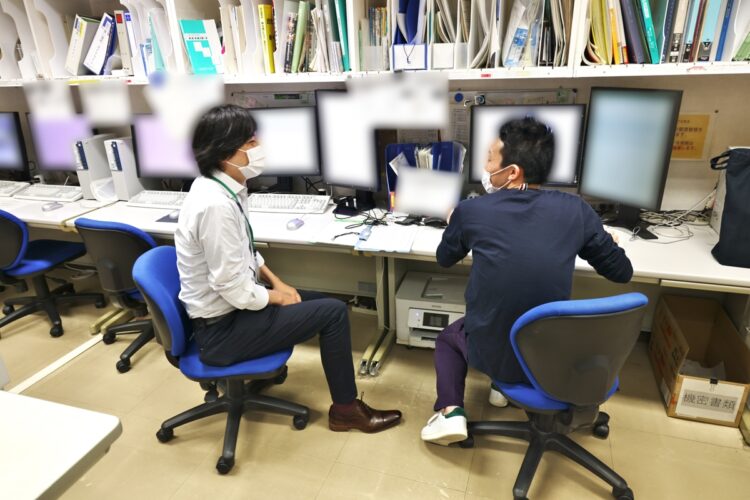 同じ下部消化管グループの助教・諏訪雄亮医師（右）と、その日の手術のスケジュールや手術後の患者の容態などの情報を共有