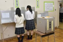 2016年の第24回参議院議員選挙で、高校の校内に設けられた期日前投票所で投票をする生徒(時事通信フォト)