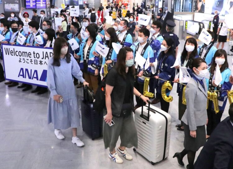 新型コロナウイルスの感染拡大が落ち着き、海外からの観光客受け入れが一部再開。成田空港に到着した団体ツアー客（時事通信フォト）