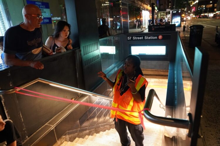 2019年7月13日、ニューヨーク大停電が起きたときの地下鉄駅。地下鉄が利用できなくなっている状況を説明する職員（AFP＝時事）