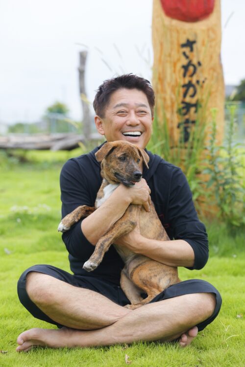 犬と触れ合う笑顔の坂上