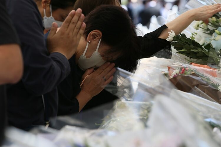 手を合わせる一般の弔問客（写真／JMPA）