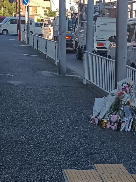 花束とお酒、菓子などが手向けられていた事故現場の交差点