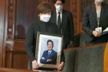 安倍元首相の写真を手に傍聴席に現われた昭恵夫人（時事通信フォト）