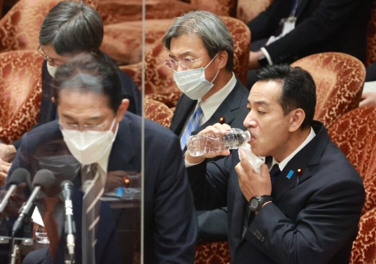 衆院予算委員会で水を飲む山際大志郎前経済再生担当相（右）。手前は答弁する岸田文雄首相。10月24日、国会内（時事通信フォト）