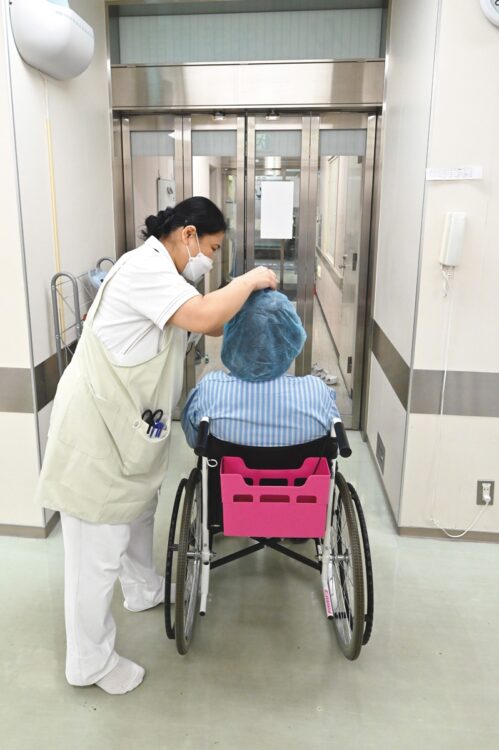 【8】看護師に付き添われながら退室：術後は片方の眼しか見えないので、安全のため車椅子に乗って手術室から退室する
