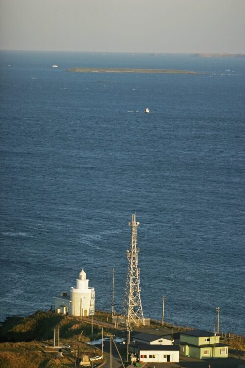 手前にある白い建物は納沙布岬灯台（塔高13.5メートル）。奥には歯舞諸島が見える（撮影／山本皓一）