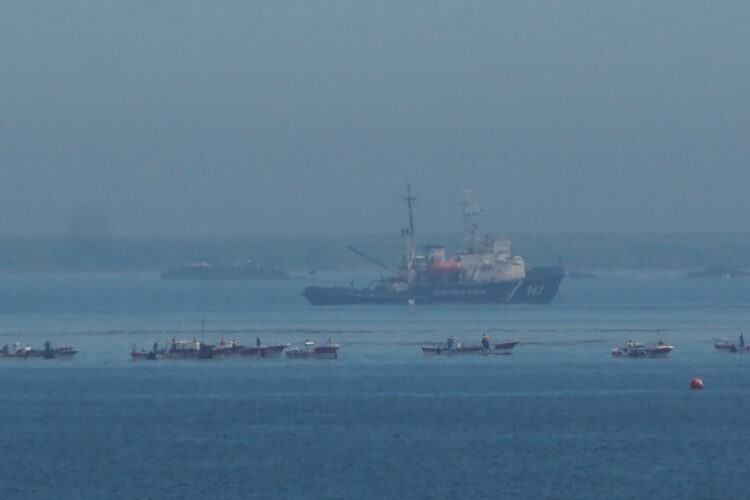 漁の様子は巨大なロシア船に常に見張られている。右手前の赤いブイ（浮き）は、日露の“中間線”を示す