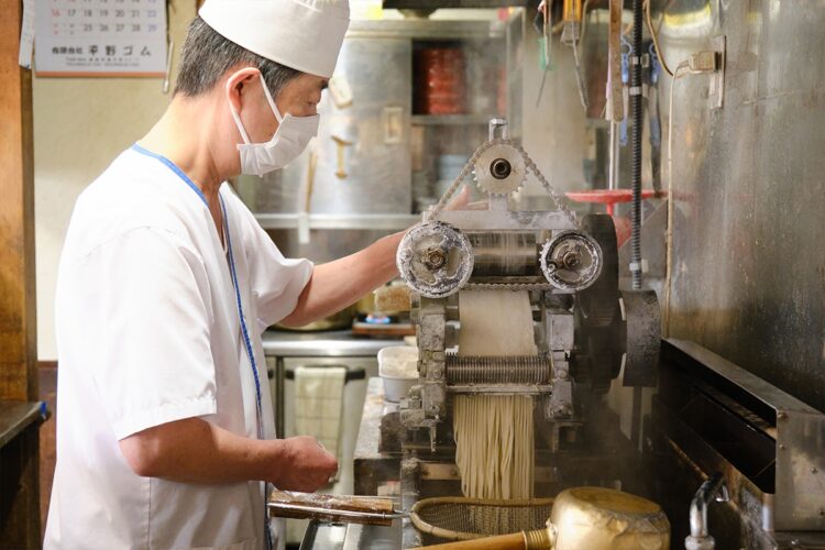 専用製麺機で平打ちねじれ麺をつくる広瀬さん