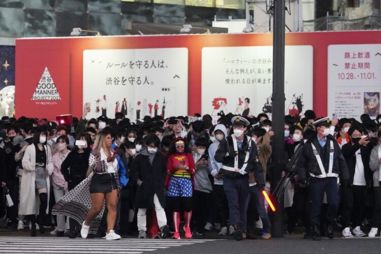 ハロウィーン本番を前に、大勢の人で混雑する渋谷のスクランブル交差点を警備する警察官（時事通信フォト）