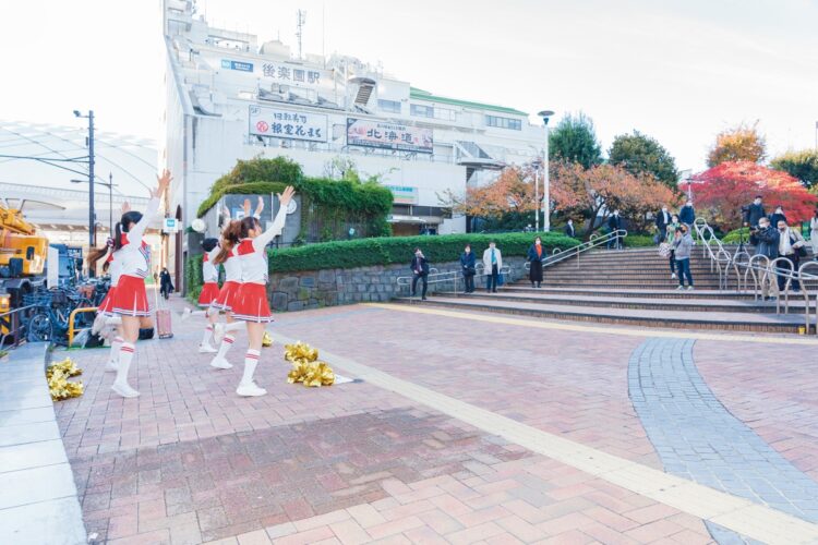 駅から出てきて足を止め、遠巻きに眺める人たちも