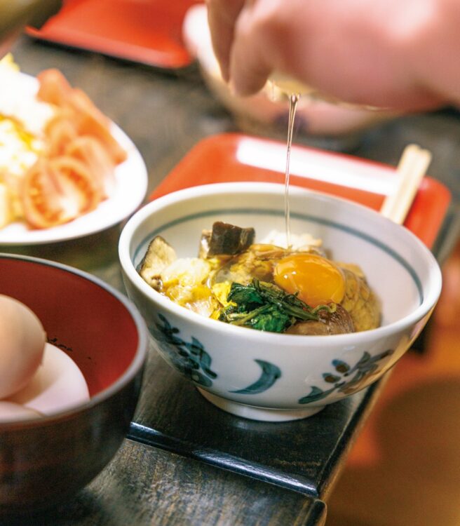 一般的なすき焼きと異なり、器に盛り付けた上から卵を割りのせ、具材と卵をからめながら食べるスタイル