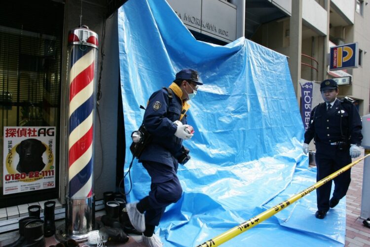 金庫があった部屋の壁に穴が開けられ、貴金属が奪われた宝飾店を現場検証する捜査員ら。2009年2月（時事通信フォト）