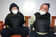 移送される前の小島智信容疑者（右）、渡辺優樹容疑者。フィリピン・マニラ首都圏のビクタン収容所［フィリピン法務省提供］（AFP＝時事）
