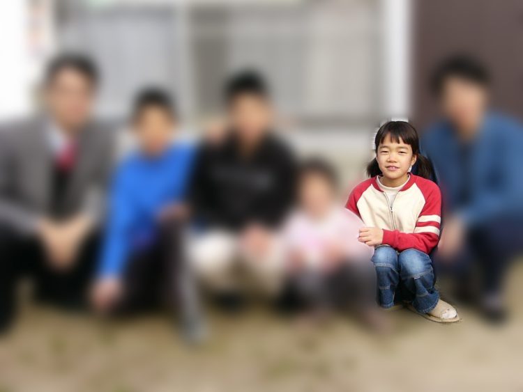 小学生の時の家族写真。小川さんの1人目の妹（左隣）は家に戻ってきた