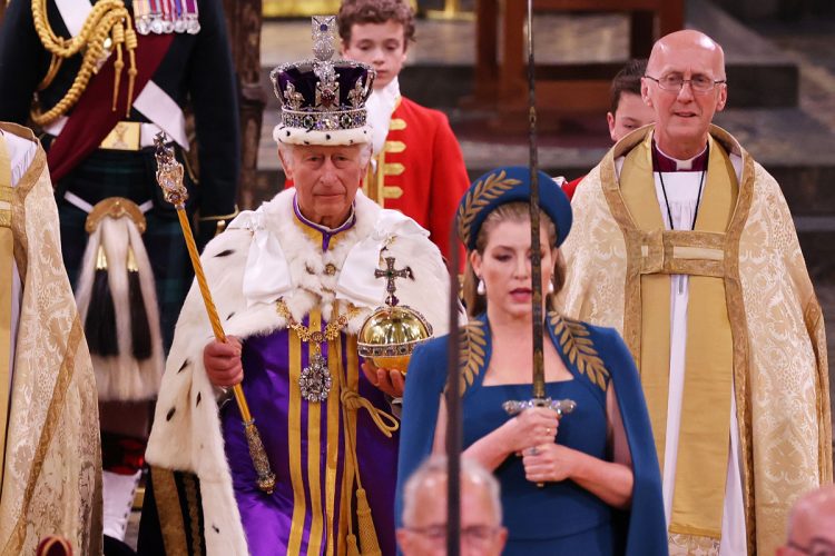 頭上に輝く「聖エドワードの王冠」、携えた宝珠や王笏は王位の象徴として使用される王室宝器「レガリア」と呼ばれる。写真は宝剣を伝達する儀式の様子で、国王の前を歩くペニー・モーダント枢密院議長は女性として初めて剣を持つ役割を果たした