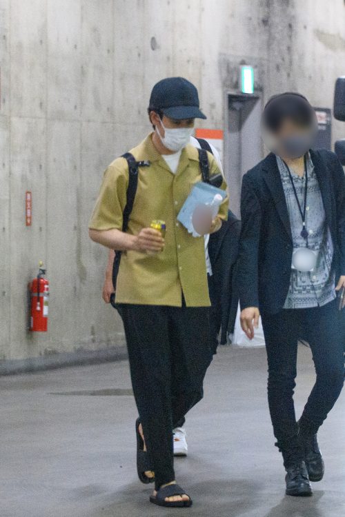 都内の劇場から半袖シャツ姿で現れた