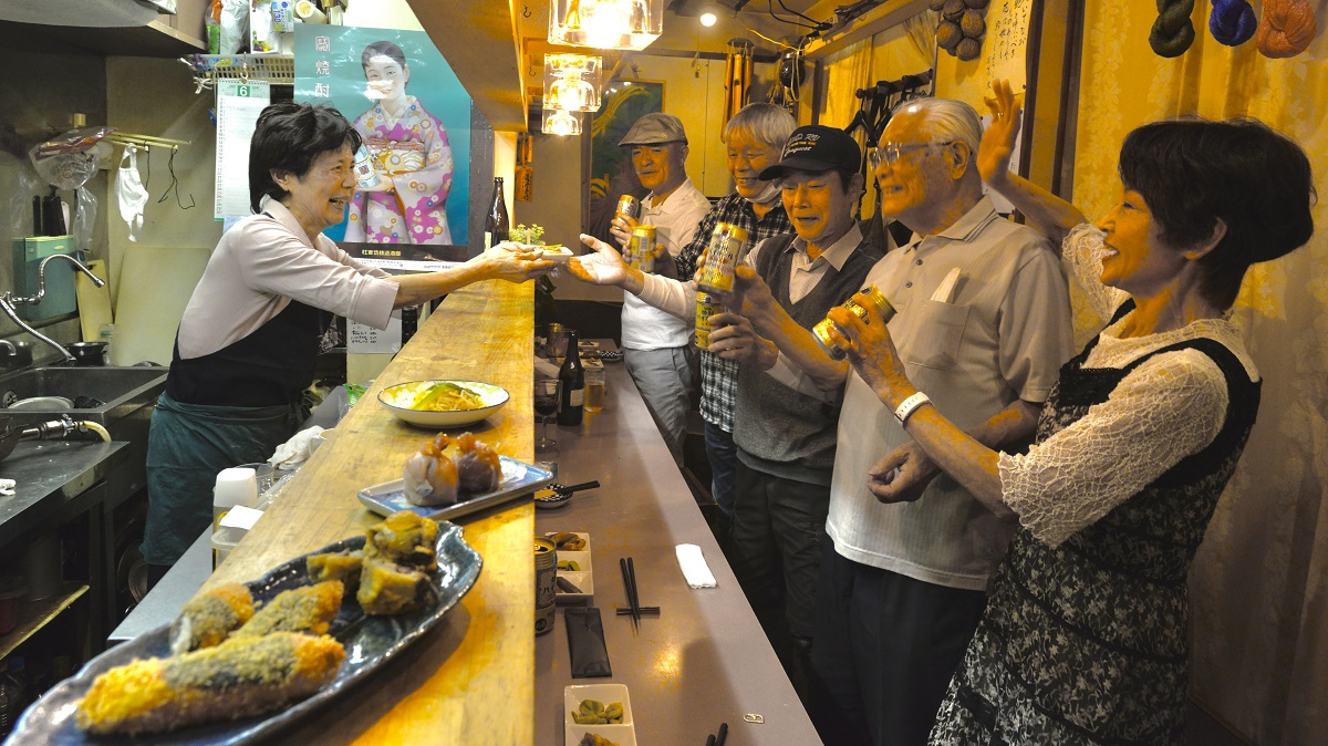 芙美子さんお手製の料理を前に客たちの笑顔が弾ける