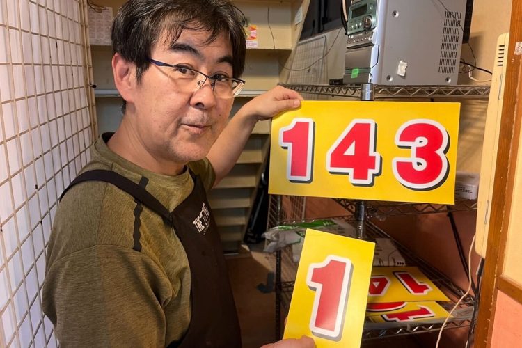 商店街で「日本一早いマジック」の数字を減らす担当を務める尾島さん