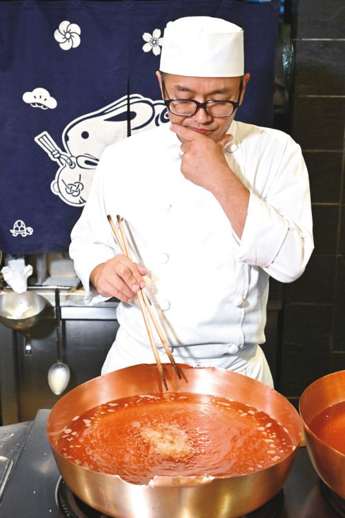温度の異なる2つの銅鍋を駆使し、じっくり揚げる2代目店主の佐藤光朗さん
