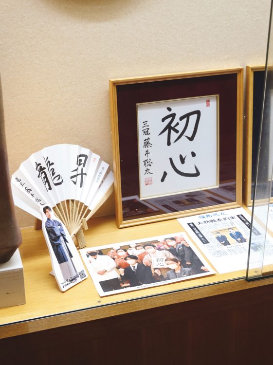 女将の若松さんが受け取った揮毫色紙は館内に展示されている