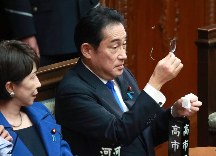 衆院本会議場で眼鏡を拭く岸田文雄首相（右）。メガネは岸田首相のイメージに欠かせない（時事通信フォト）