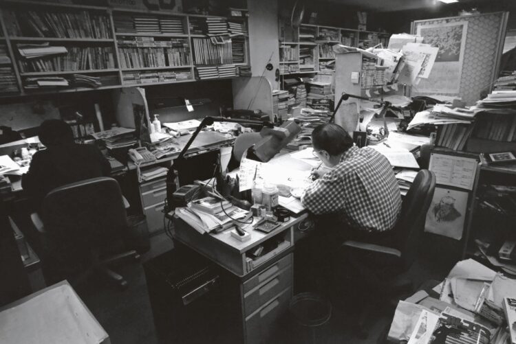 在りし日のさいとう氏の作業風景（2000年撮影）。スタッフと机を並べてペンを走らせる