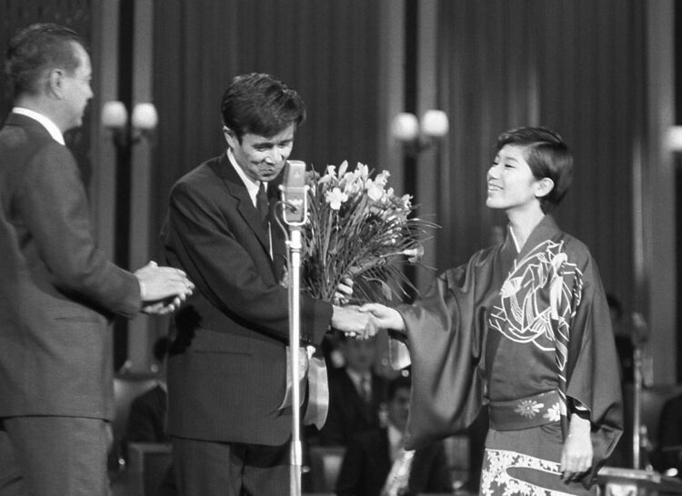 第１０回日本レコード大賞にて作詩賞に輝いた星野さん（左）に、祝福の握手をする水前寺（右）