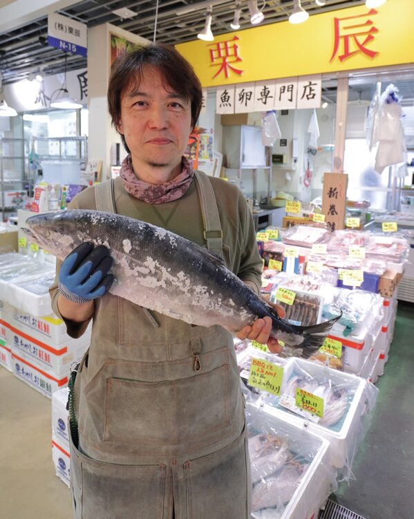 贈答用におすすめだという『厚岸産　時鮭』（時価）を持つ店長・前田晃明さん