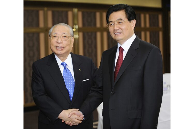 2008年、東京都内のホテルで階段を前に胡錦濤国家主席と握手する池田名誉会長（時事通信フォト）