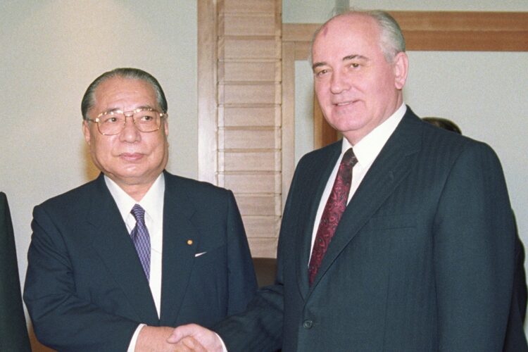 1992年、ゴルバチョフ旧ソ連大統領と階段を前に握手する池田名誉会長（時事通信フォト）