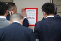 「特定抗争指定暴力団」に指定されたことを示す標章を貼る捜査員ら（イメージ、時事通信フォト）