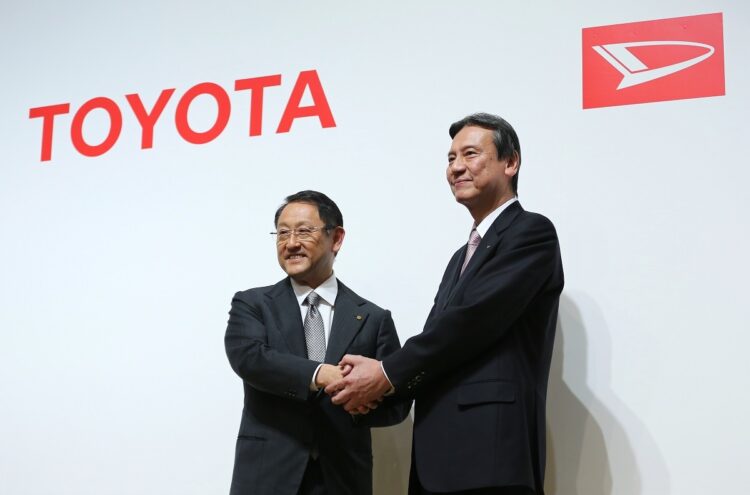 1998年に出資率をあげてトヨタ自動車がダイハツ工業を子会社化、2016年には全額出資し完全子会社化した。完全子会社化の記者会見で握手するトヨタ自動車の豊田章男社長（左）とダイハツ工業の三井正則社長（いずれも当時）（時事通信フォト）