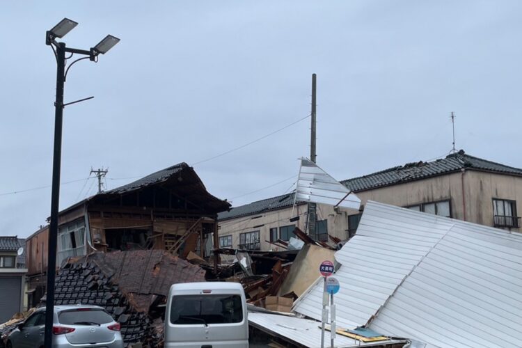 家屋が道路にかぶさり、救助する人々の行手を阻む（2024年1月4日撮影）