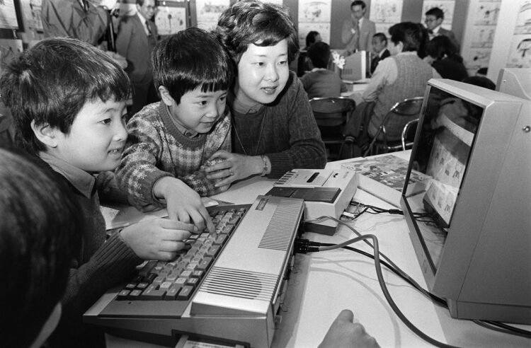 1984年、パソコン教室で熱中する母子たち。キーボードの向こう側に見えるのが、カセットテープを記録媒体として読み込むデータレコーダ（時事通信フォト）