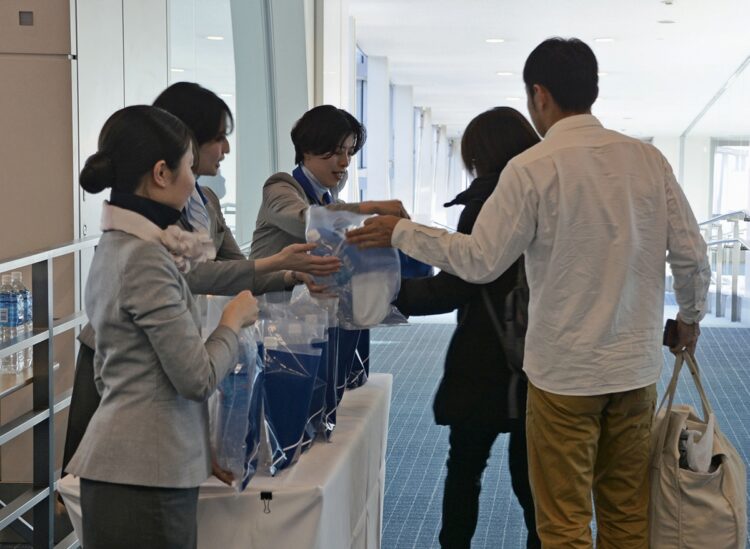 27日、運航を取りやめていた能登空港で旅客便が運航再開。羽田空港では能登空港行きの乗客に全日空スタッフから水が配られた（共同通信社）