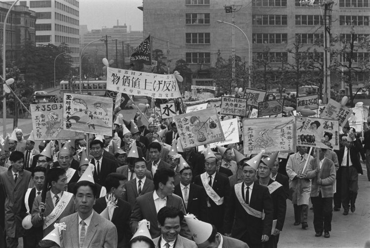 1964年、第35回中央メーデーでプラカードを手にデモ行進する労組員（時事通信フォト）