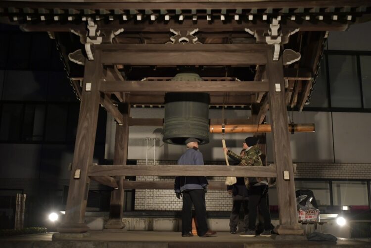 新年を迎え、都内の寺で除夜の鐘をつく参拝客。東京都新宿区（イメージ、時事通信フォト）