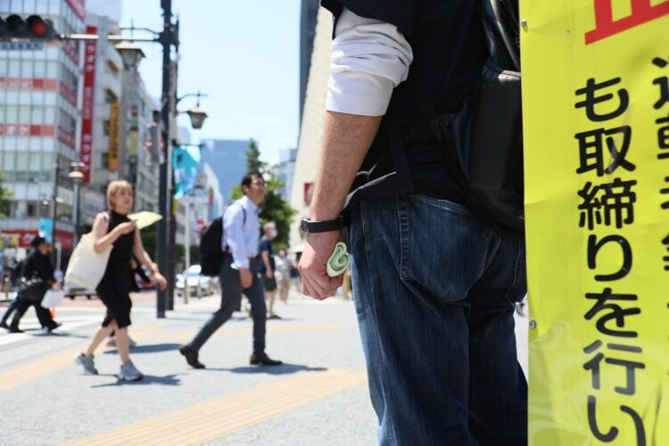 顔写真を記憶し、繁華街やターミナル駅など人混みの中で見つけ出す捜査手法「見当たり捜査」を街頭に立って行っている警察官。AIが発達した今でも逮捕に繋がりやすい有効な捜査方法として世界中で用いられている（イメージ、時事通信フォト）