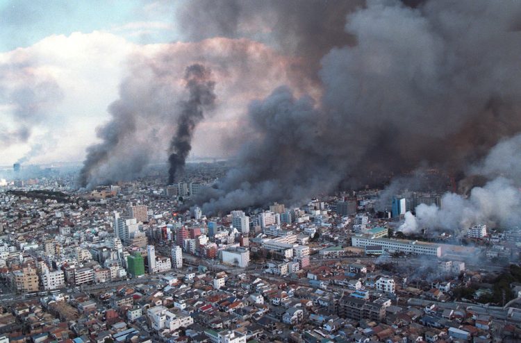 直下型だった阪神・淡路大震災で何か所も火の手が上がり煙に覆われる神戸市上空。（兵庫県／1995年、時事通信フォト）