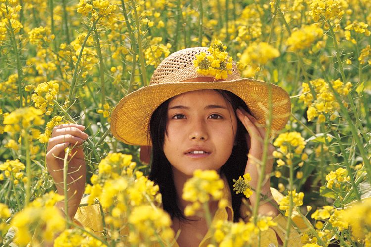 菜の花畑で戯れる。麦わら帽子がよく似合っている。